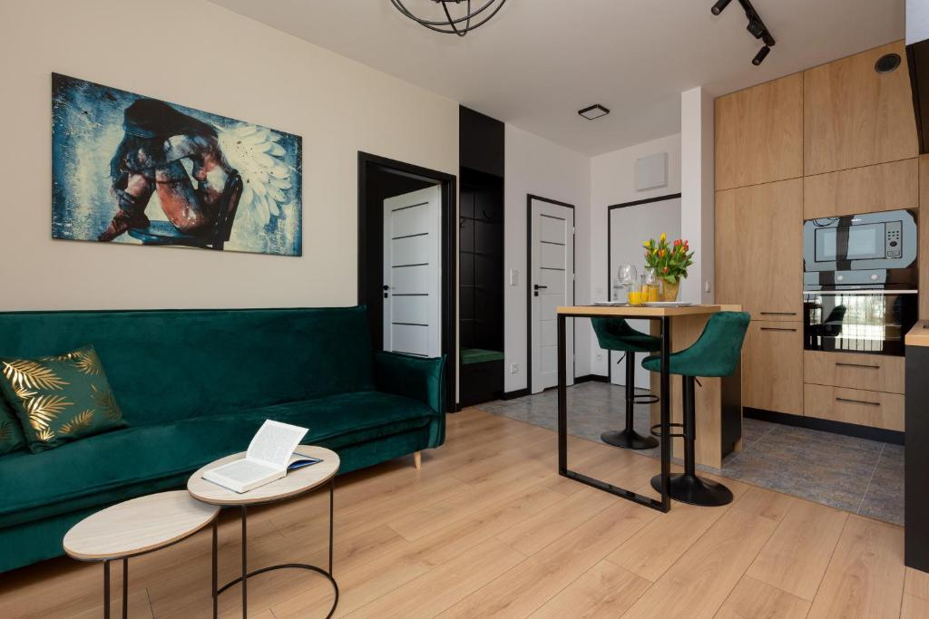 a living room with a green couch and a table at Home Factory Estate Praga Kotsisa by Renters in Warsaw