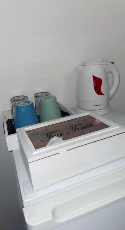 una nevera blanca con 3 tazas y una taza de café en Chambre cosy, en Arles