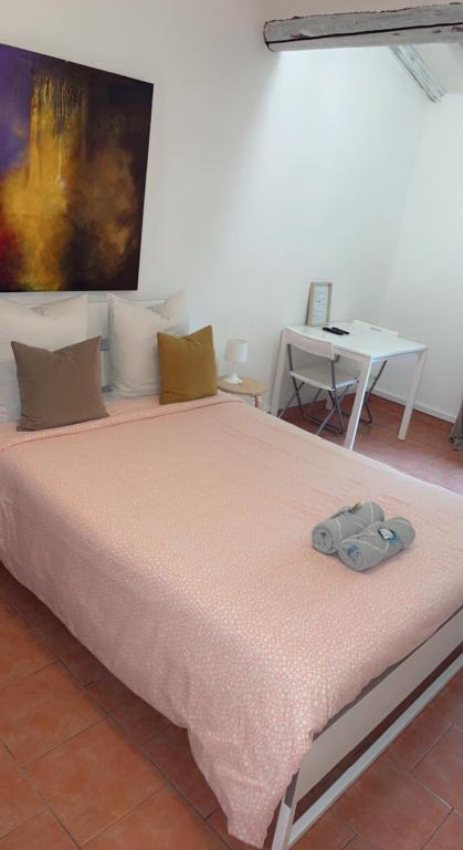 una cama con un par de zapatos sentados en ella en Chambre cosy, en Arles