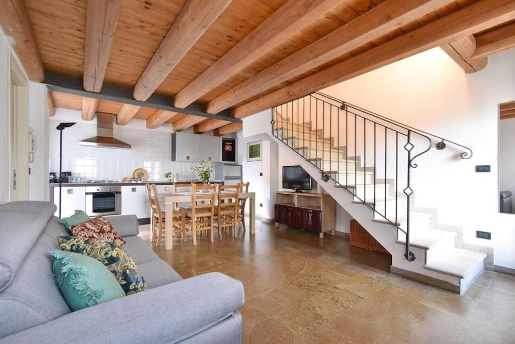 uma sala de estar com um sofá, uma cozinha e uma escadaria em Calaone Wondeful Duplex Apartment con parcheggio x4 em Baone