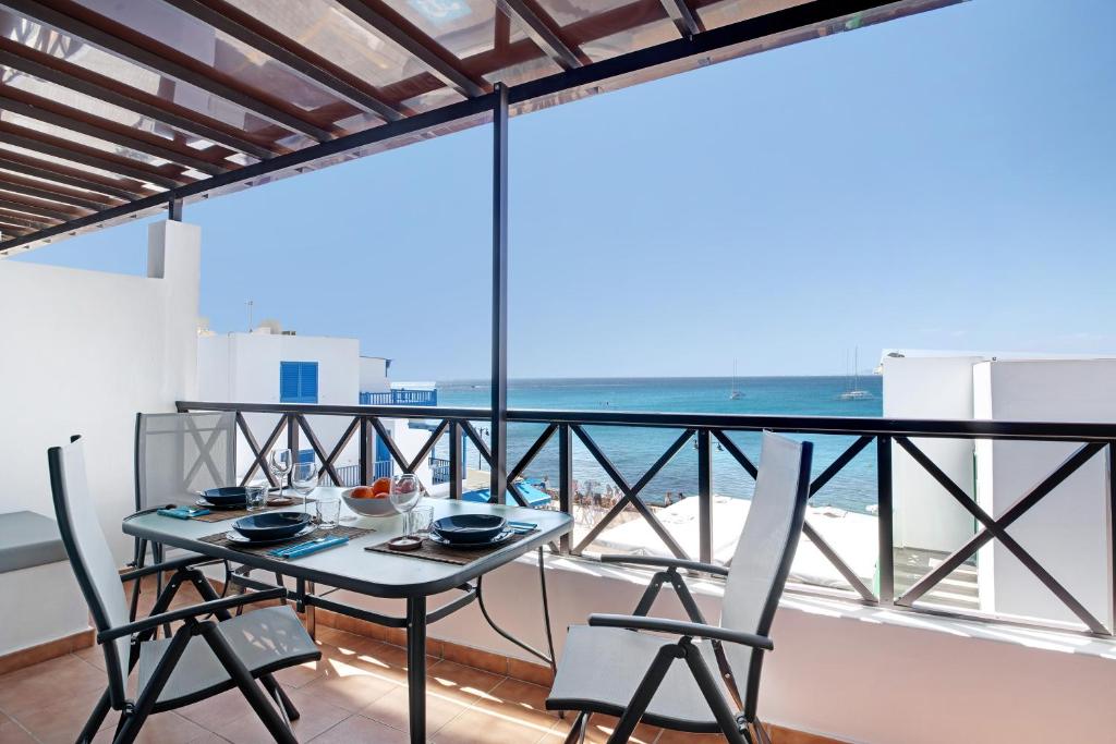 stół i krzesła na balkonie z widokiem na ocean w obiekcie Apartamento La Estrella ii w mieście Playa Blanca