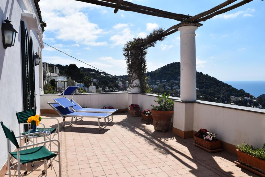 Un balcón con sillas y vistas al océano. en La Terrazza Apartment, en Capri
