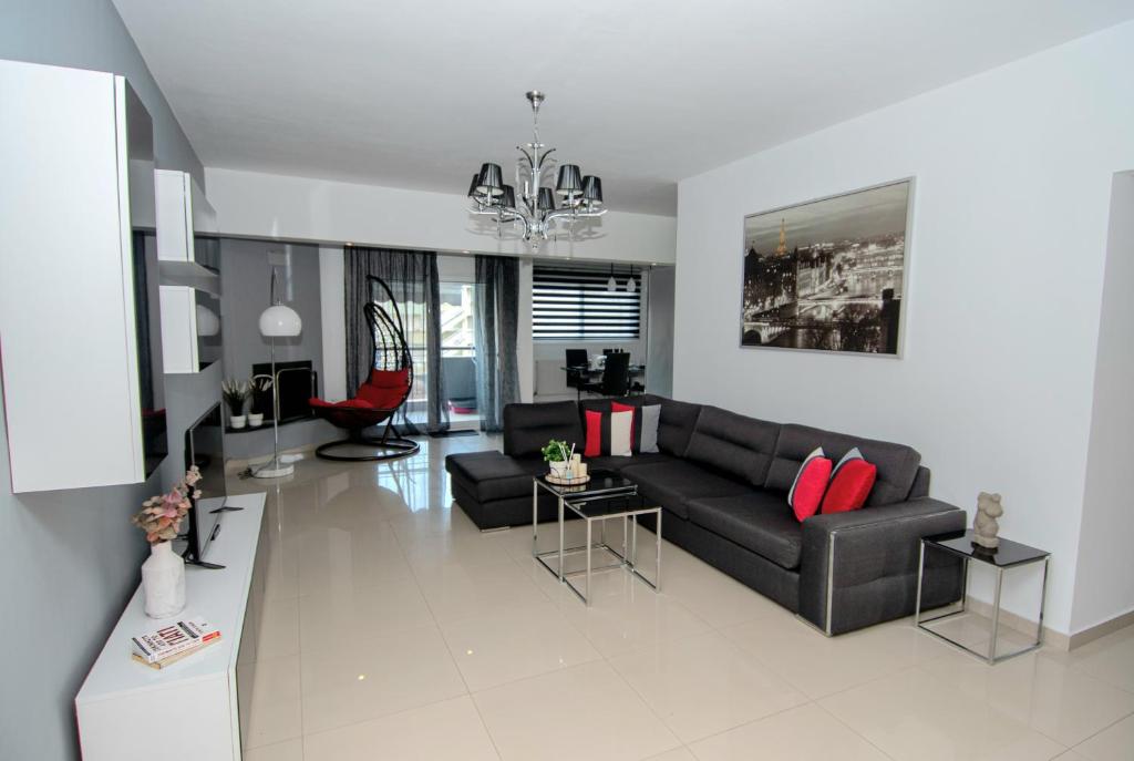 salon z czarną kanapą i czerwonymi poduszkami w obiekcie Mistral Luxury Living w mieście Néa Péramos