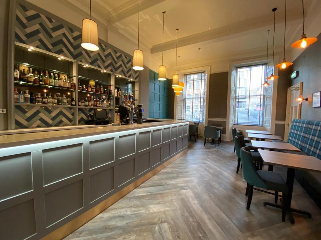 a bar in a restaurant with tables and chairs at 28 York Place Hotel in Edinburgh