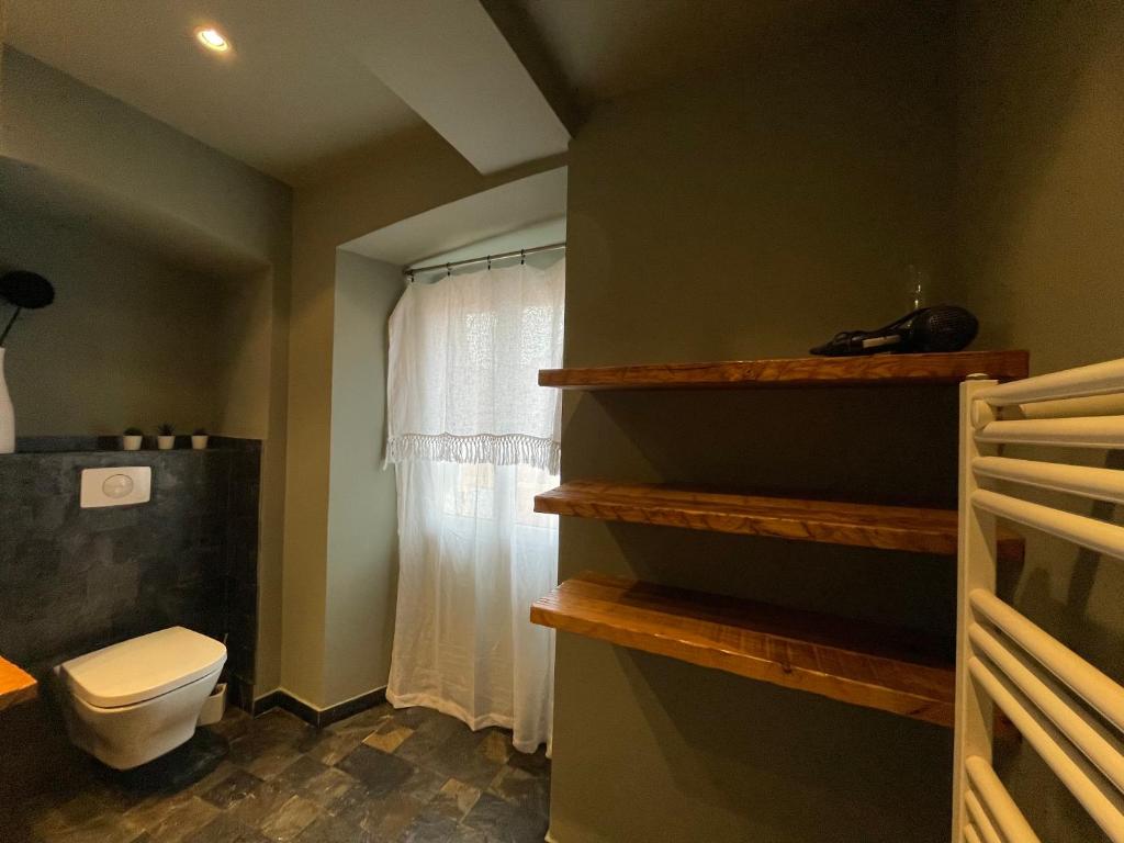 a bathroom with a toilet and a window at CASA MANTINUM au coeur de la Citadelle in Bastia