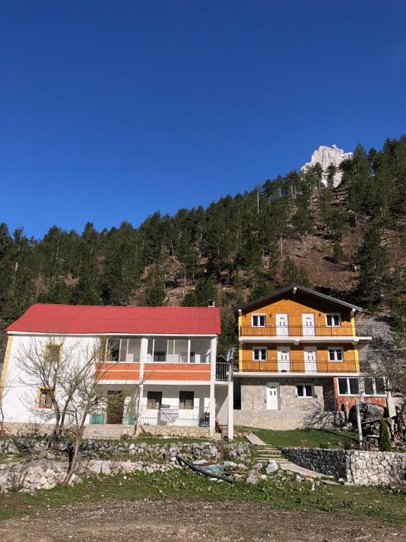 un grupo de edificios frente a una montaña en Bujtina Brahim Selimaj en Valbonë