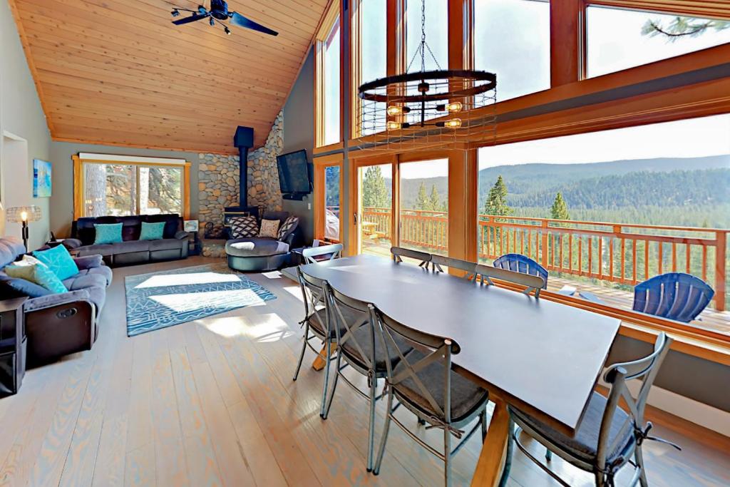 uma sala de estar com uma mesa e cadeiras e uma varanda em Ridgeline Panorama em Truckee