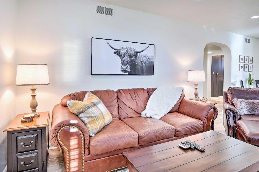 拉皮德城的住宿－Cozy Rapid City Retreat Perfect for Exploring!，客厅里一张棕色的皮沙发,墙上挂着一头牛
