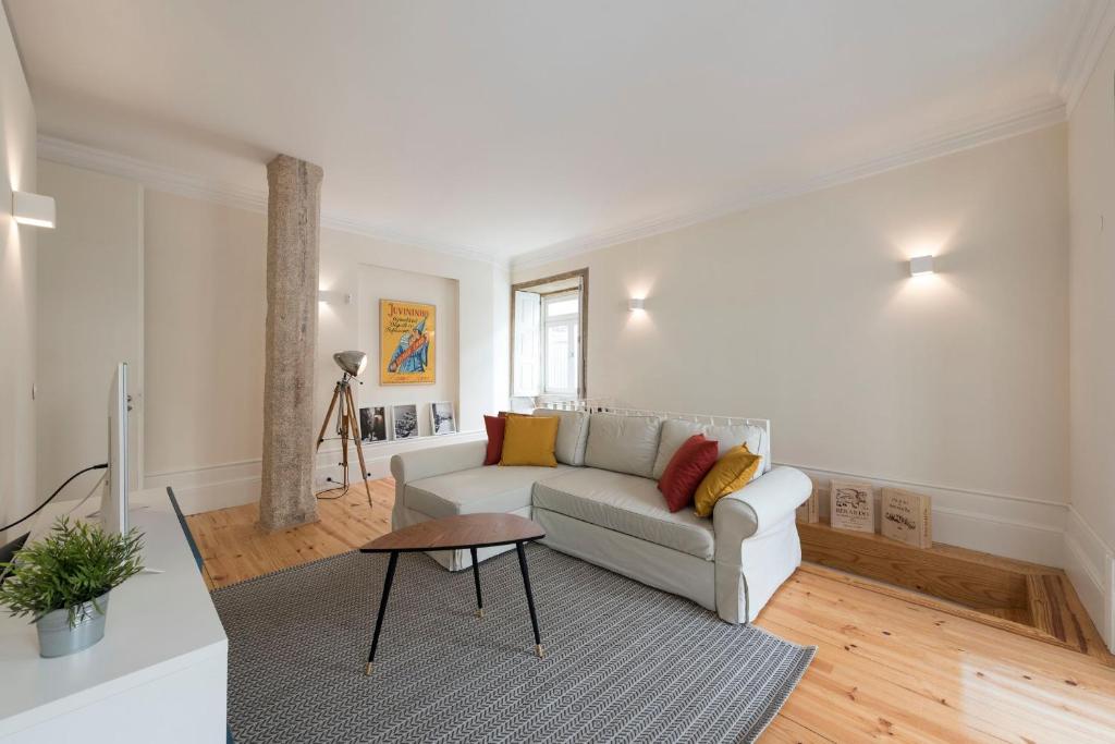 ein Wohnzimmer mit einem Sofa und einem Tisch in der Unterkunft Duplex Wonder In Sé W/ Patio by LovelyStay in Porto
