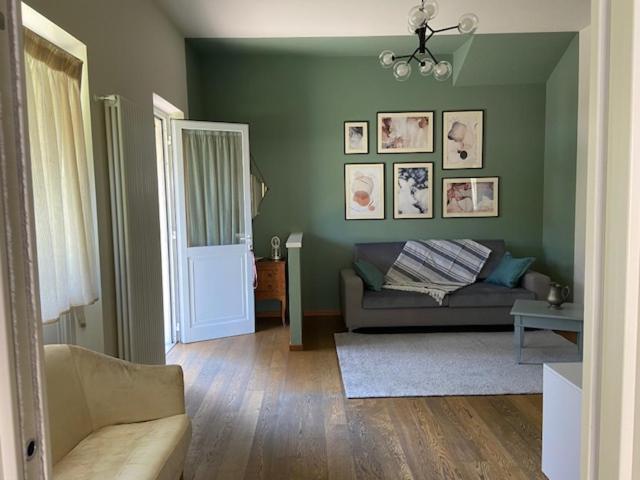 uma sala de estar com um sofá e uma parede verde em Casa Marì em Garda