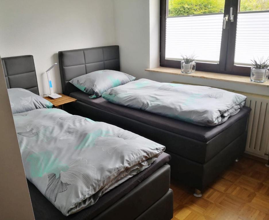 dos camas sentadas una al lado de la otra en una habitación en Apartment Lieblingsort, en Kreuzwertheim