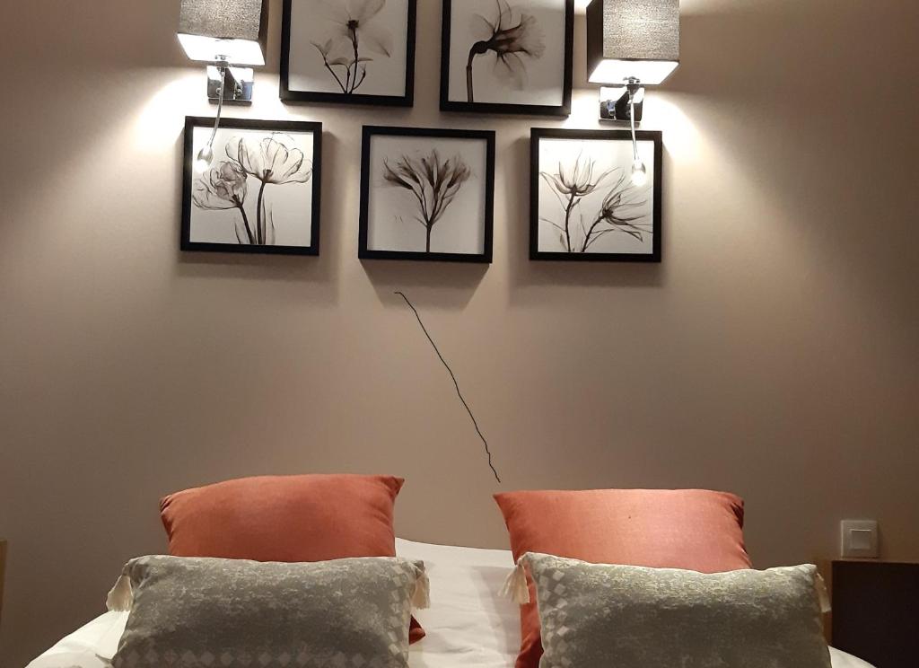 a bedroom with four pictures hanging on a wall at Logis hôtel le relais de l'abbaye in Saint-Évroult-Notre-Dame-du-Bois