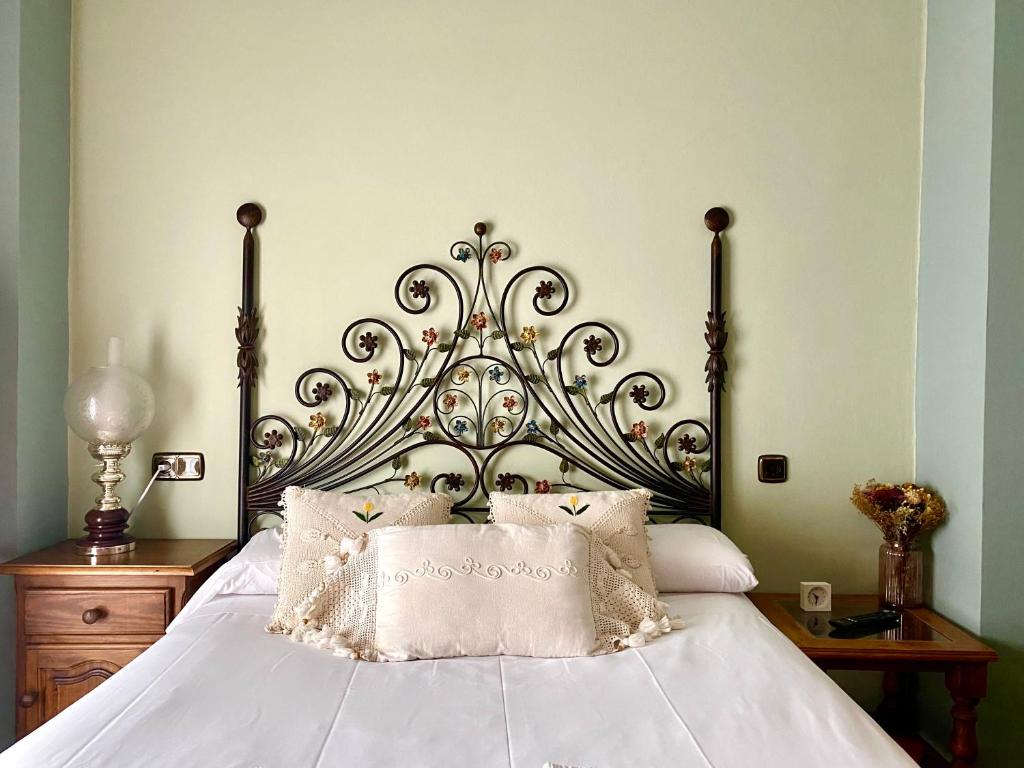 a bedroom with a large white bed with a metal headboard at Housing León Marigold in León