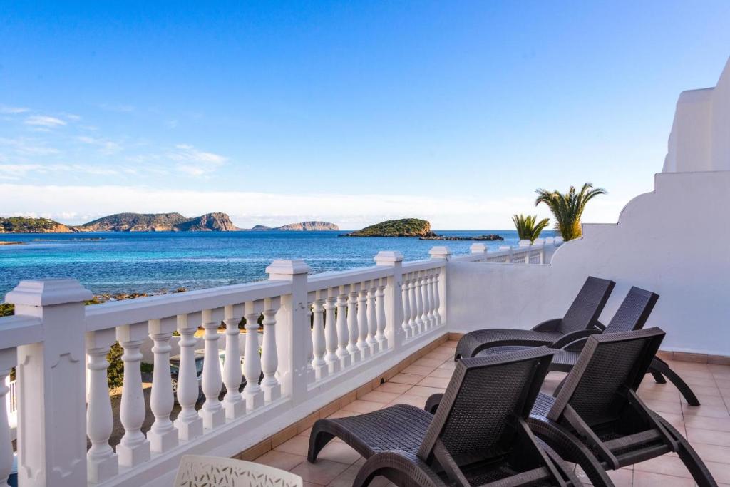 Un balcón con sillas y vistas al océano. en Jacaranda Apartments & Studios, en Es Canar