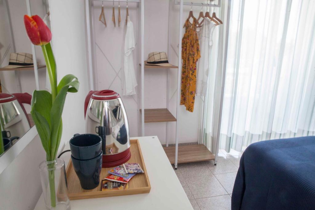 una habitación con cafetera y un jarrón de flores sobre una mesa en Hotel Villa Lina, en Riccione