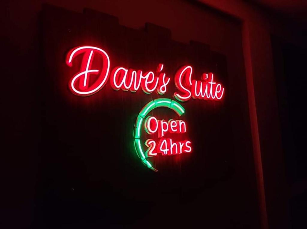 a neon sign that says dancessie open hrs at Daves Suite in Sipocot