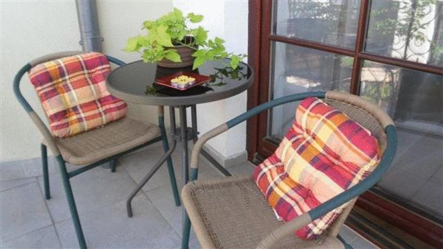 einen Tisch mit zwei Stühlen und einen Tisch mit einer Pflanze in der Unterkunft Apartament Kopernik in Krakau