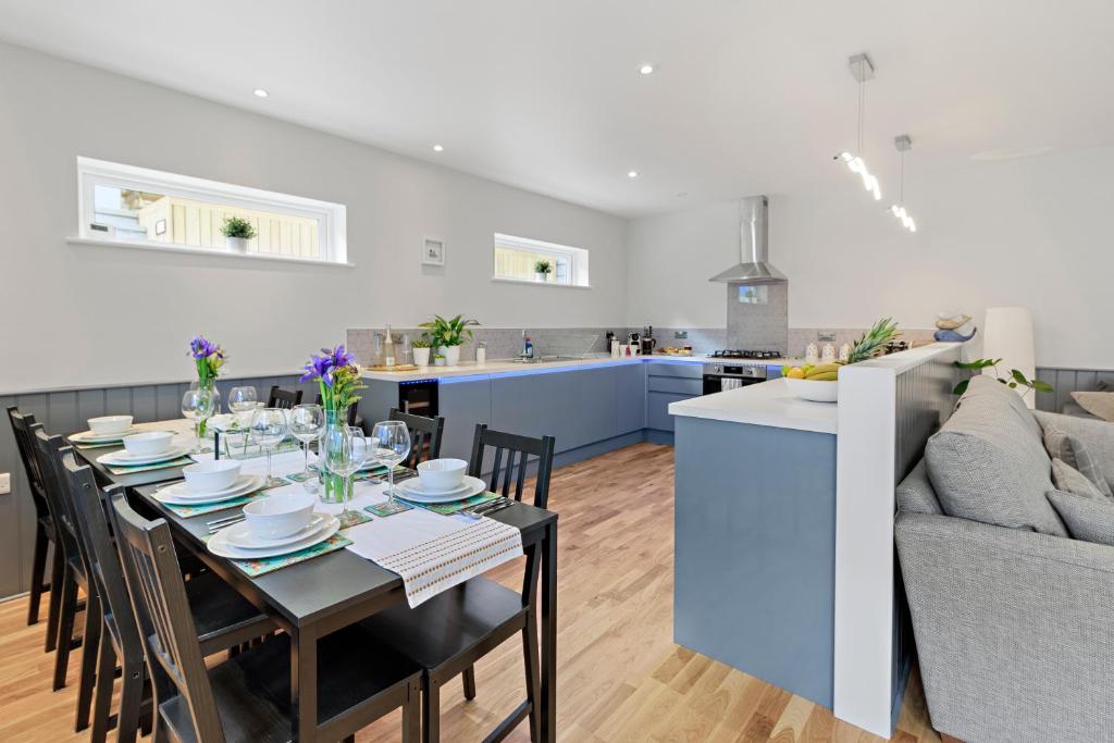 een eetkamer en een keuken met een tafel en een bank bij Admirals Place - Contemporary Townhouse With Spacious and Flexible Accommodation in Torquay