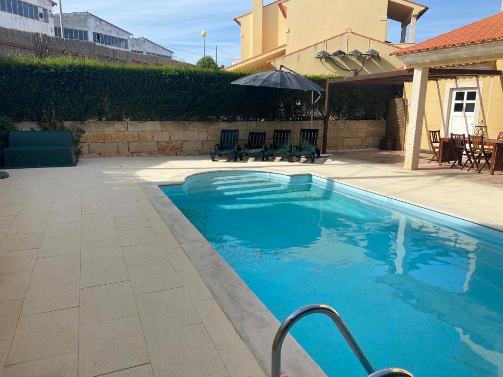 a swimming pool with blue water in a yard at Casa da quinta das hortas - serra dos mangues in São Martinho do Porto