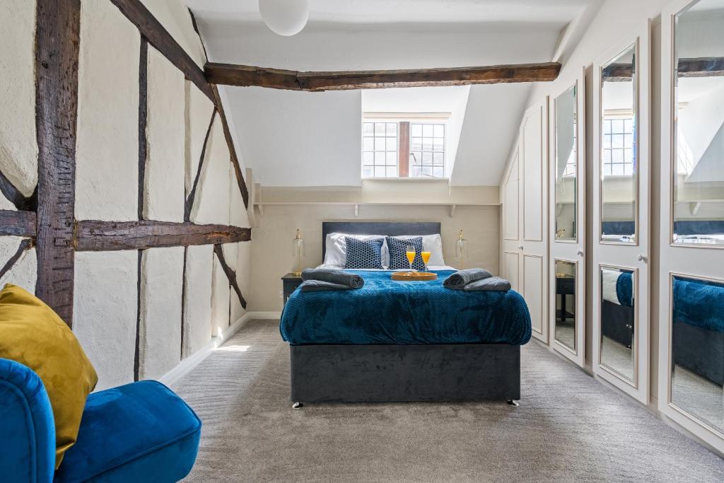 a bedroom with a blue bed and a blue chair at Characteristic 4 Bed Apartment in the Heart of Windsor in Windsor