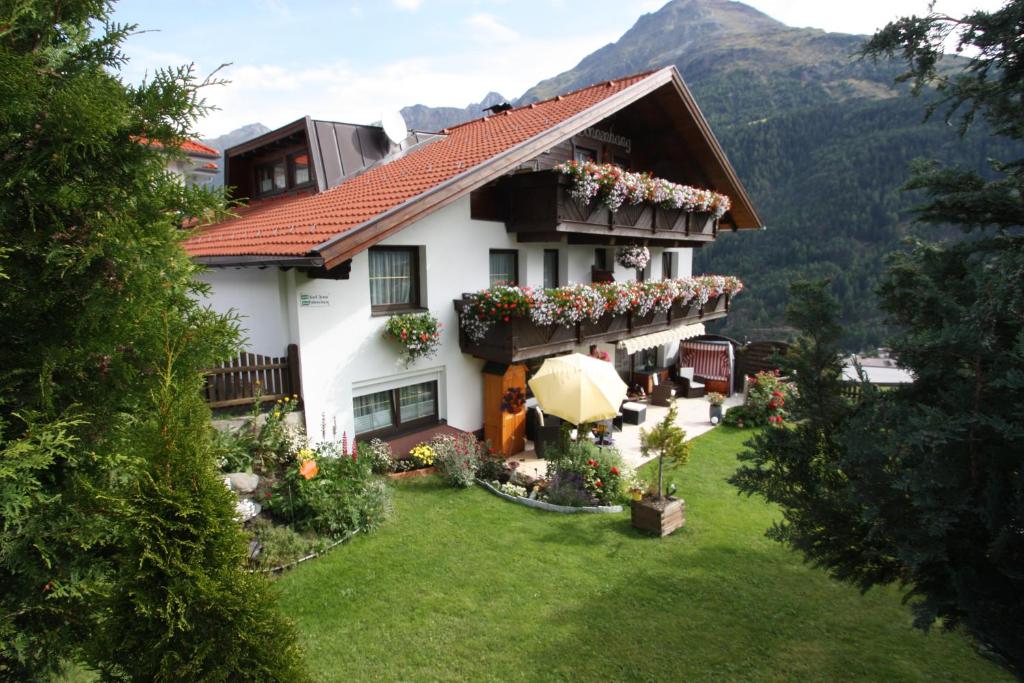 a large white house with flowers in the yard at Haus Sonnenhang in Sölden
