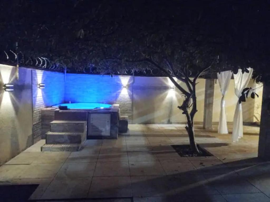un patio illuminato di notte con vasca idromassaggio di CASA COM SPA DE HIDRO, AQUECEDOR E CROMOTERAPIA A 1,0 kM DO CENTRO a Chapada dos Guimarães