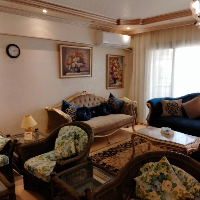 a living room with a couch and chairs at Afnan Guest- Rehab City in Burg el-Ḥudûd