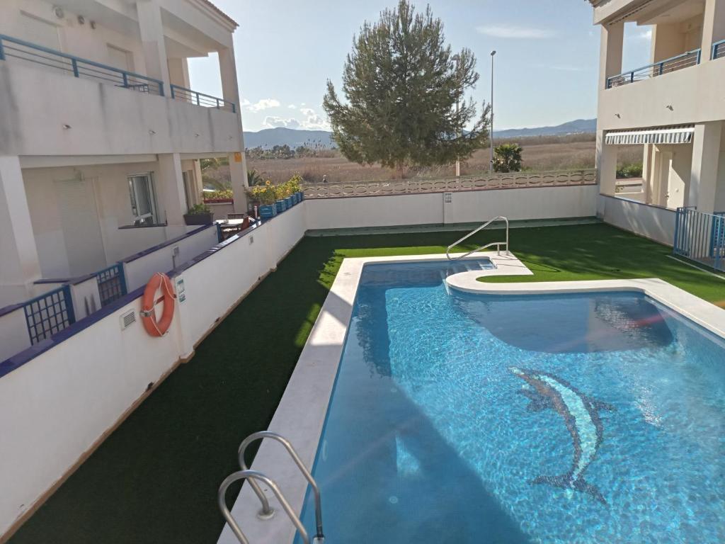 a swimming pool in the backyard of a house at PLAYA ALMARDA CORINTO, PISCINA, WIFI,2 TERRAZAS, BARBACOA,TRANQUILo in Sagunto