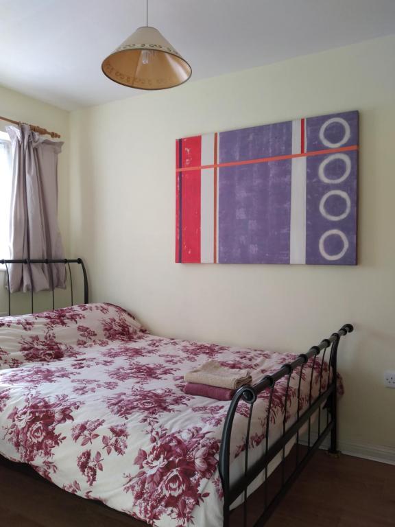 1 dormitorio con 1 cama y una pintura en la pared en 1 Double room with shared bathroom en Bracknell