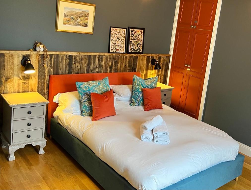 um quarto com uma cama com almofadas laranja e azul em Silver Howe, Bowness-on-Windermere em Bowness-on-Windermere