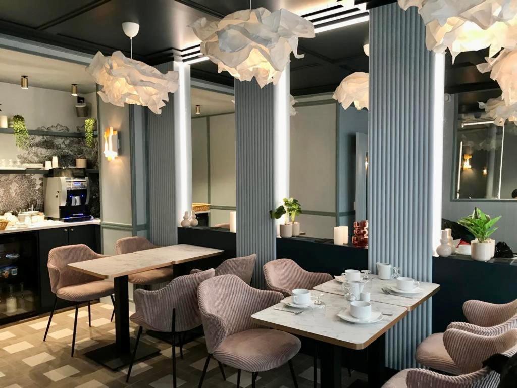 فندق Amadeus في باريس: غرفة طعام بها طاولات وكراسي وثريات