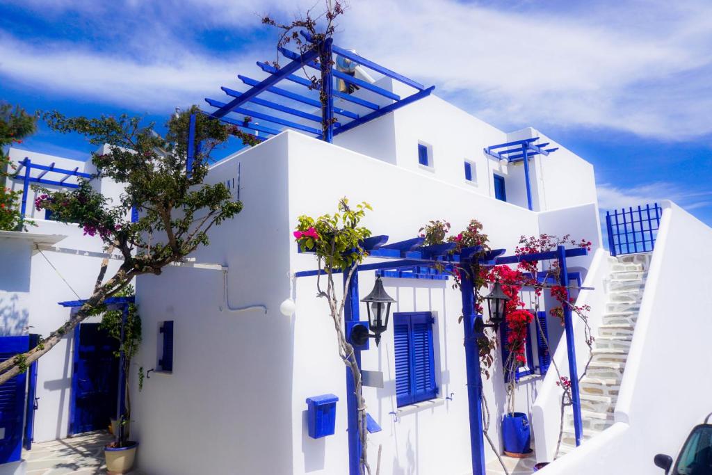 um edifício branco com portas azuis e uma árvore em Serene Hill em Naousa