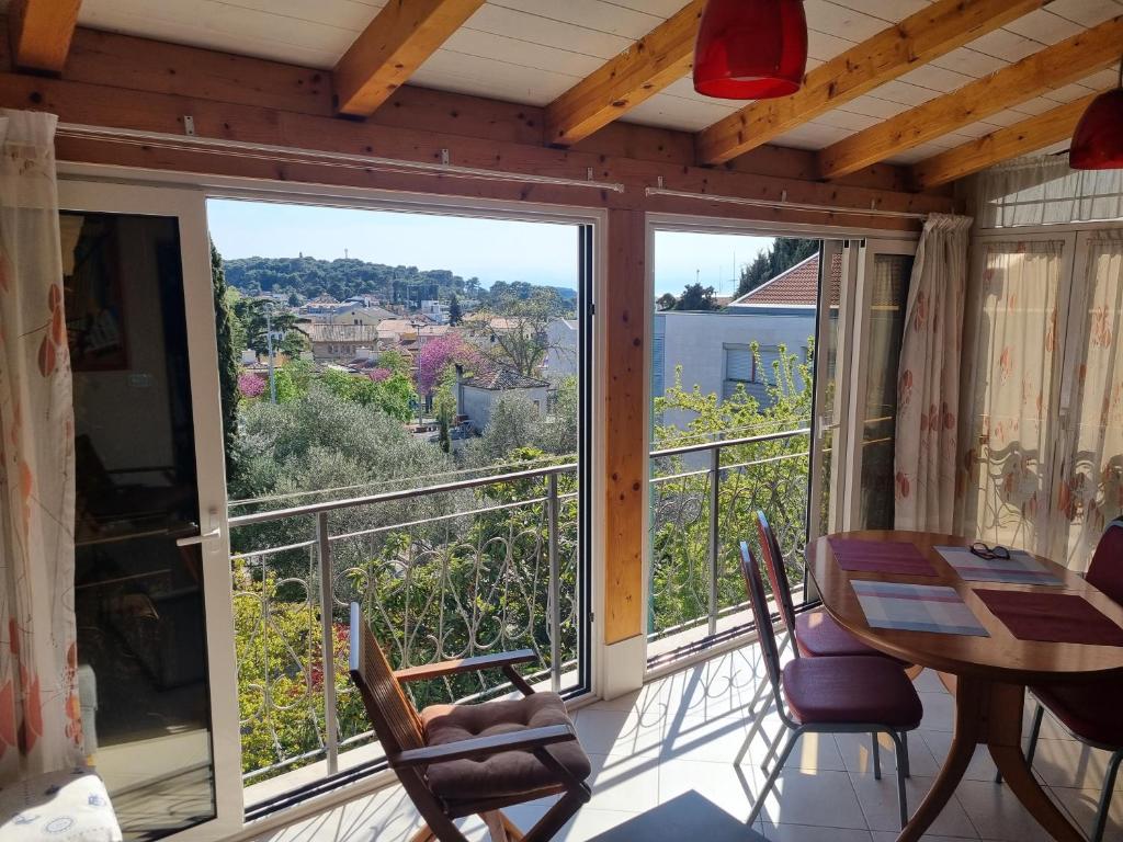 a room with a balcony with a table and chairs at Greenview Apartment with Parking in Rovinj