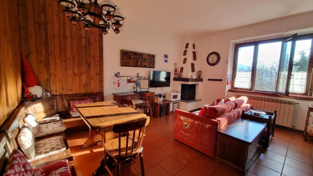 - un salon avec un canapé et une table dans l'établissement Appartamento Isabella - Residence Montesole, à Ponte di Legno