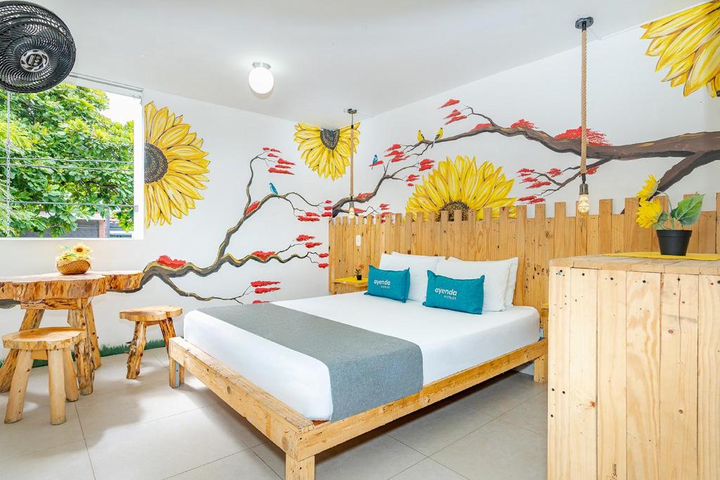 1 dormitorio con 1 cama y una pared con un mural en Ayenda Jardin de Provenza, en Medellín