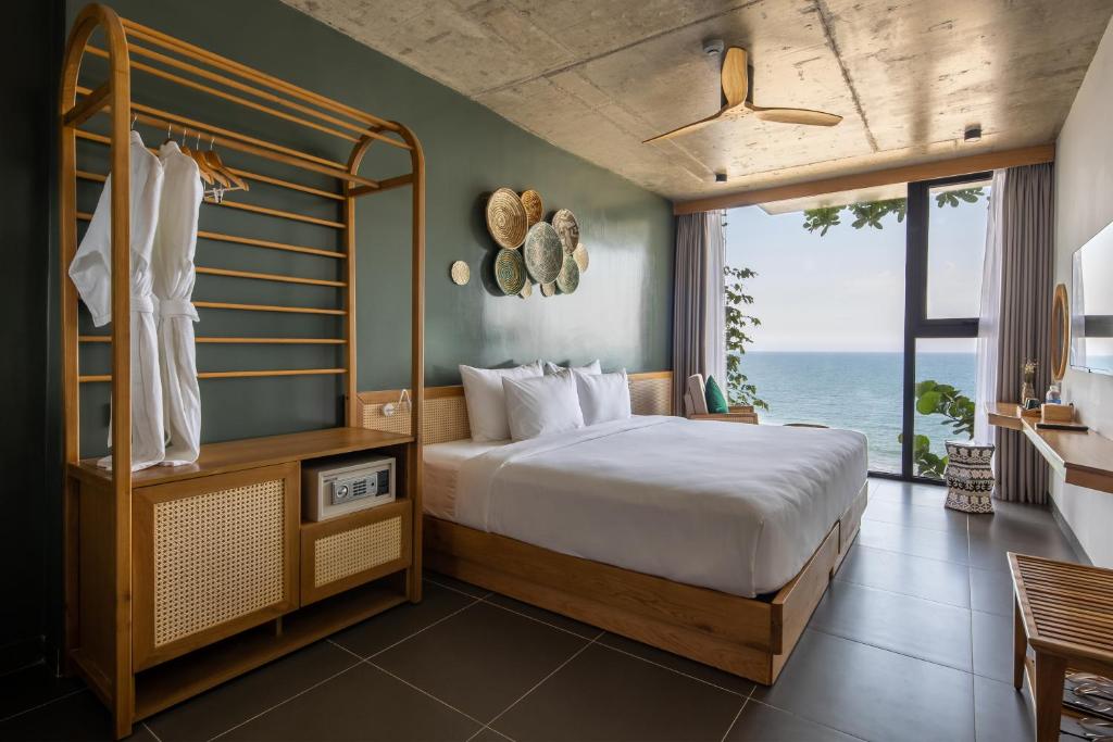 a bedroom with a bed and a view of the ocean at The Leaf Boutique in Danang