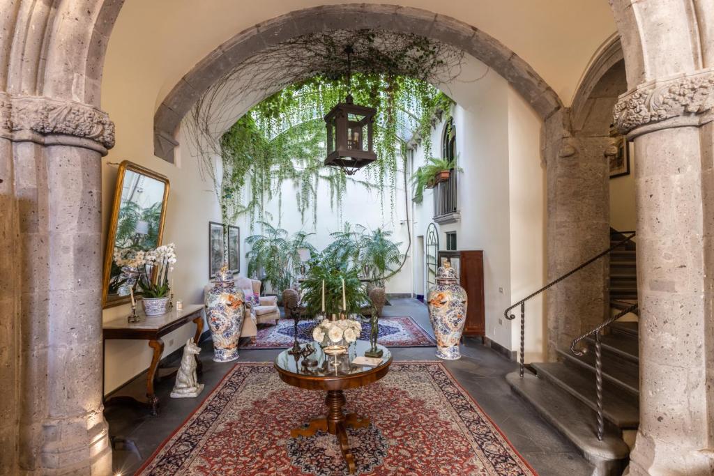 a hallway with an archway with vases and a table at Palazzo Marziale in Sorrento