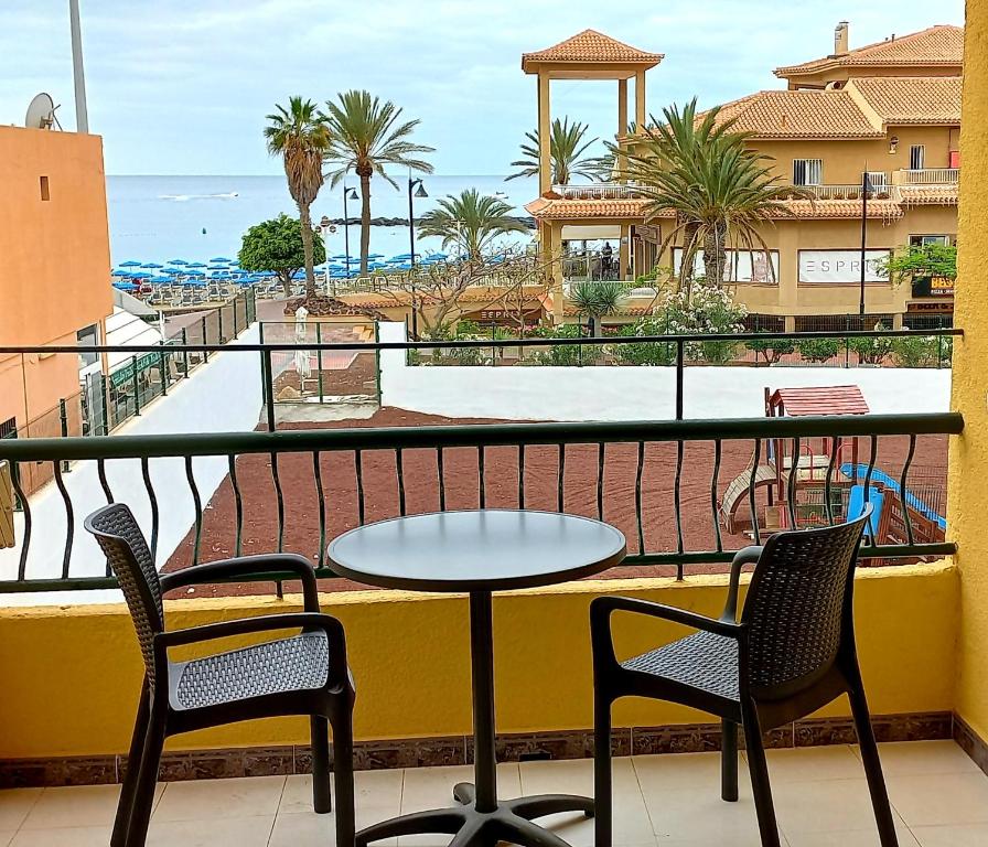 un tavolo e sedie su un balcone con vista sulla spiaggia di Apartamento Playa de las vistas Torres del Sol C3 308 ad Arona
