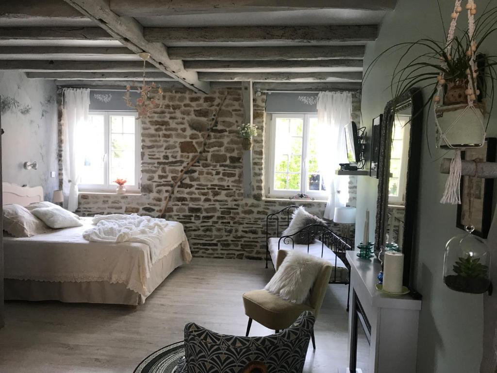 um quarto com uma cama e uma parede de tijolos em "La chambre des TISSERANDS" em Ménil-Hubert-sur-Orne
