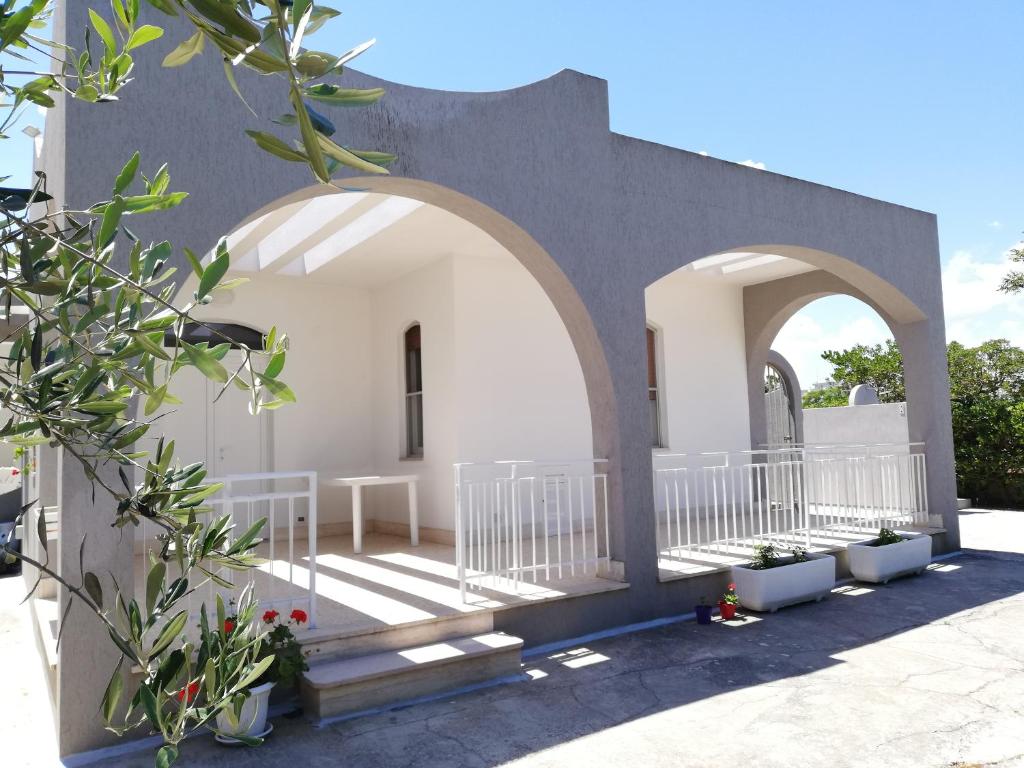 a white building with an archway and some plants at Villa Marisole in Torre Canne