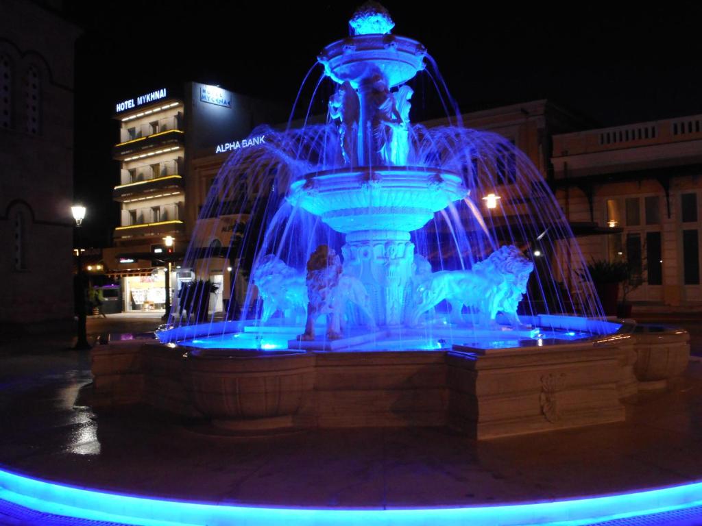una fontana con luci blu in una città di notte di Hotel Mycenae a Argos