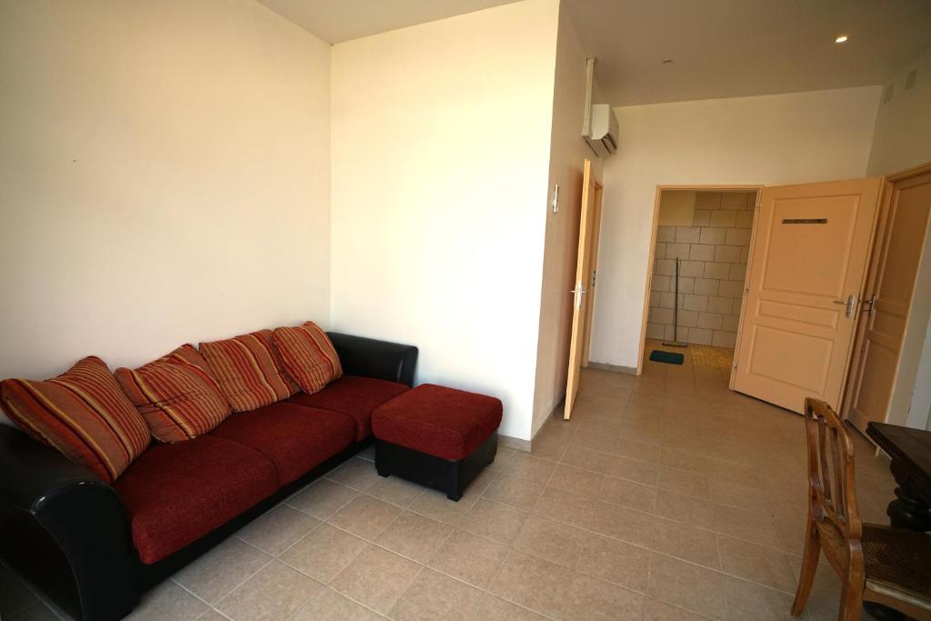 a living room with a red couch and a chair at Camping Arbre de Vie in Montagnac