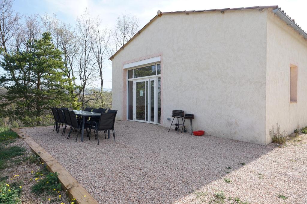 a patio with a table and chairs in front of a building at Camping Arbre de Vie in Montagnac