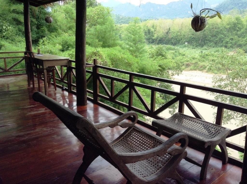 a porch with a bench and a table and a view at Lao Spirit Resort in Ban Xianglôm