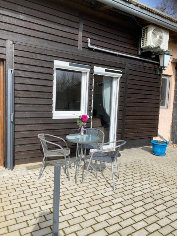 a patio with a table and chairs and a window at Spaß & Ferien auf dem Alpaka Hof 2 in Lenschow