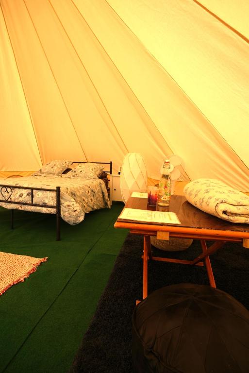a room with a tent with a table and a bed at Camping Arbre de Vie in Montagnac