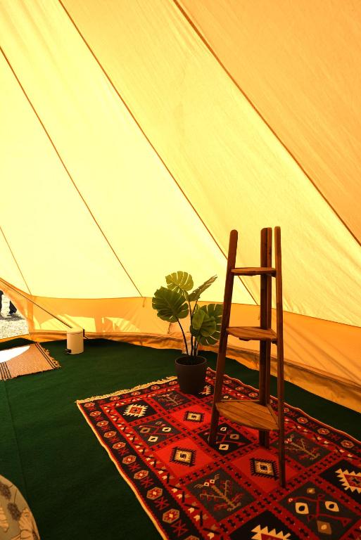 a wooden chair sitting in front of a tent at Camping Arbre de Vie in Montagnac