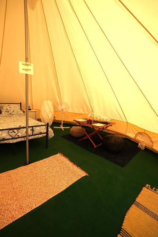 a tent with a bed and a table in it at Camping Arbre de Vie in Montagnac