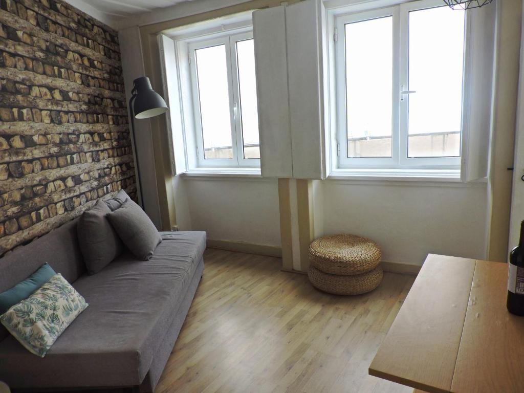 a living room with a couch and two windows at New Charming Flat - Lisbon Center in Lisbon