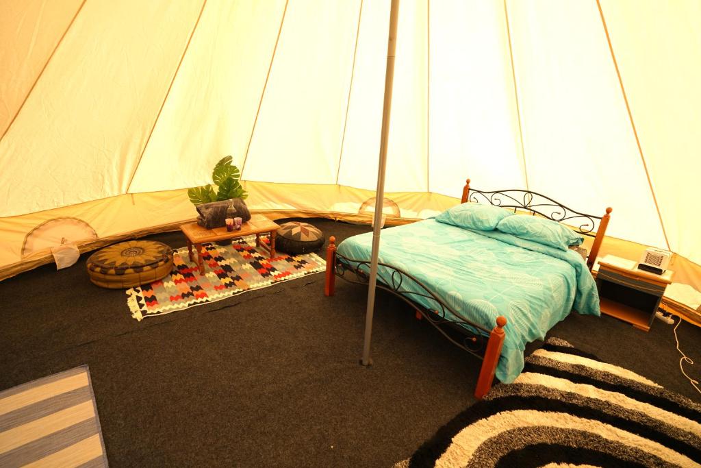 a bedroom with a bed and a tent at Camping Arbre de Vie in Montagnac